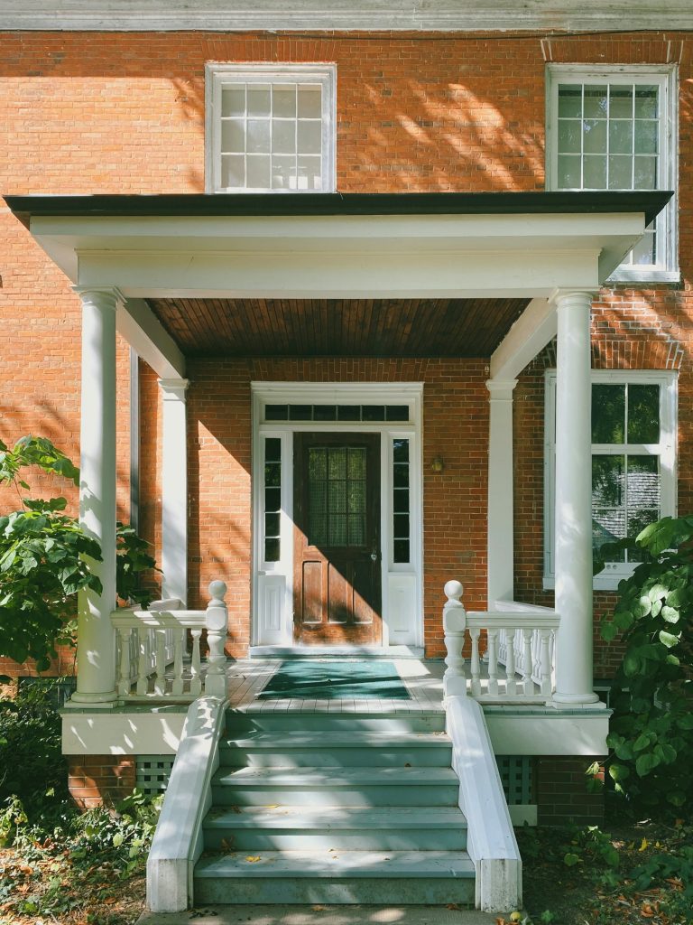 Maison en brique avec entrée et porte blanche